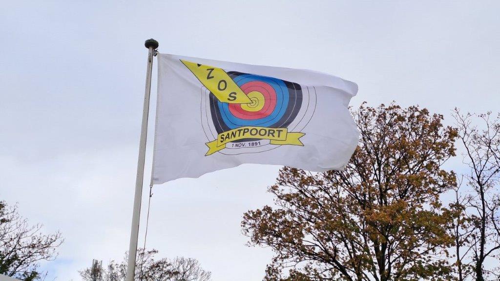 Een wapperende vlag van de VZOS met het logo erop.